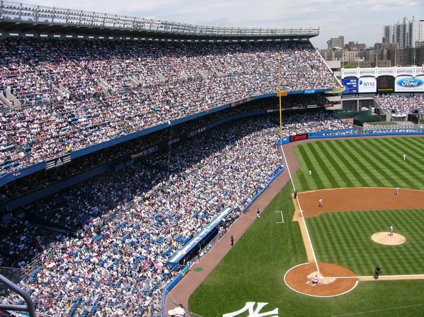 Security personnel managing a dense crowd at a Jay-Z concert at Yankee Stadium.