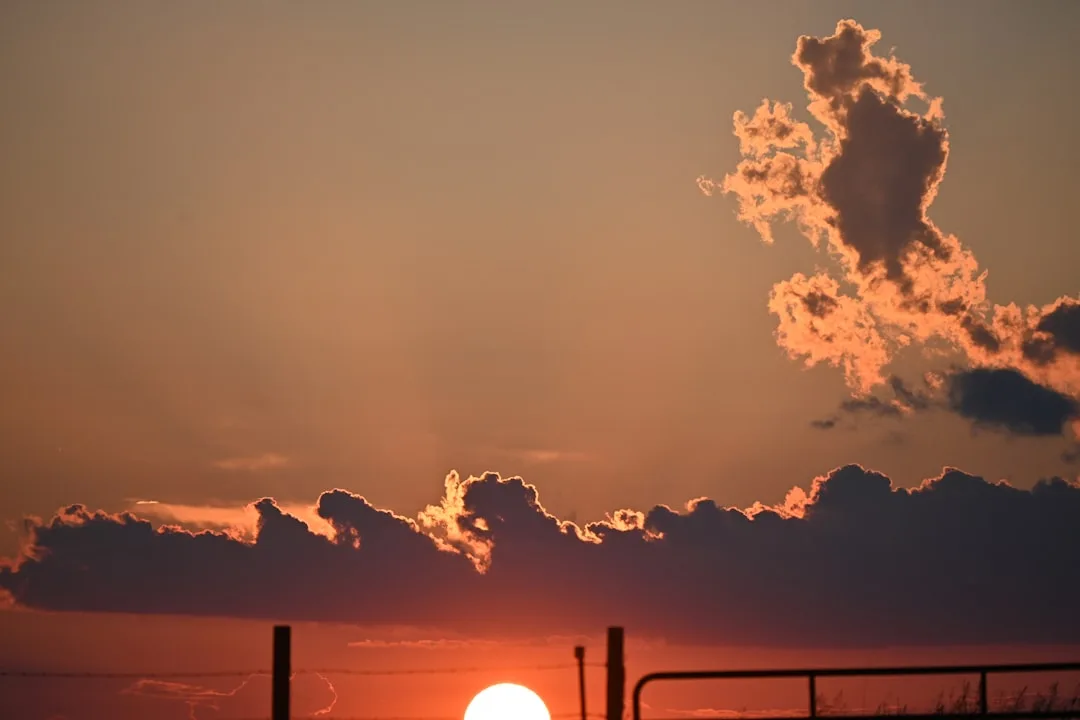 Partly cloudy summer skies over an Oklahoma neighborhood during a period of cooler weather and heat relief.