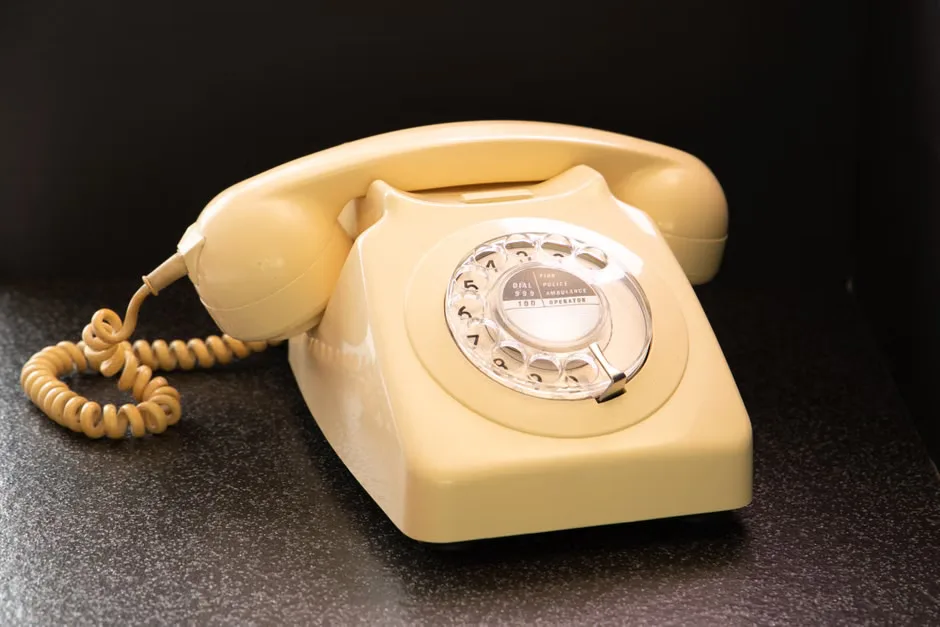 A retro-style landline phone for children displayed on a table in a family home.