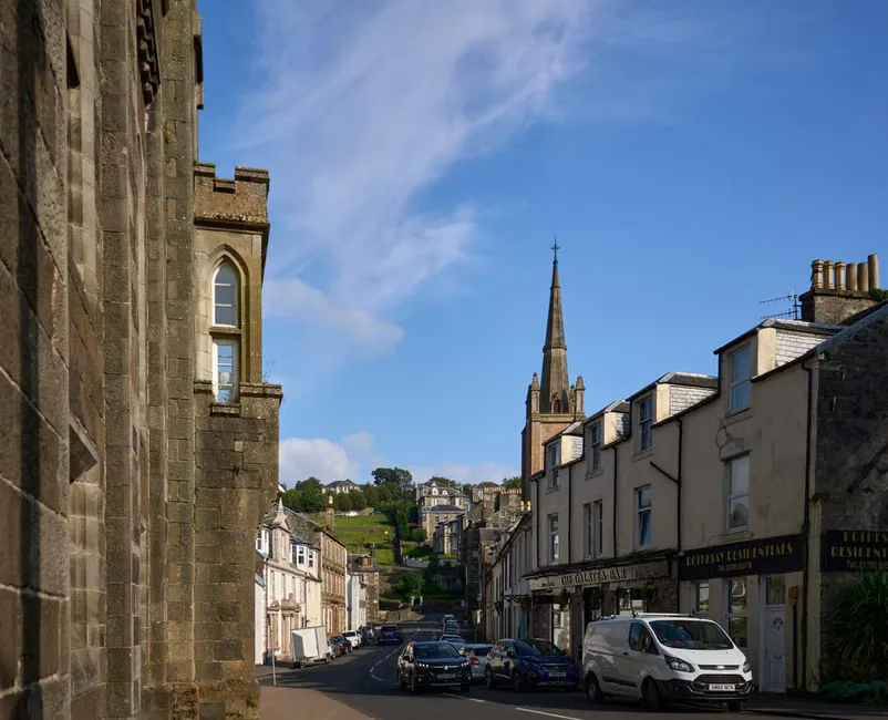A UK town center with pedestrians and cultural venue banners on a high street.