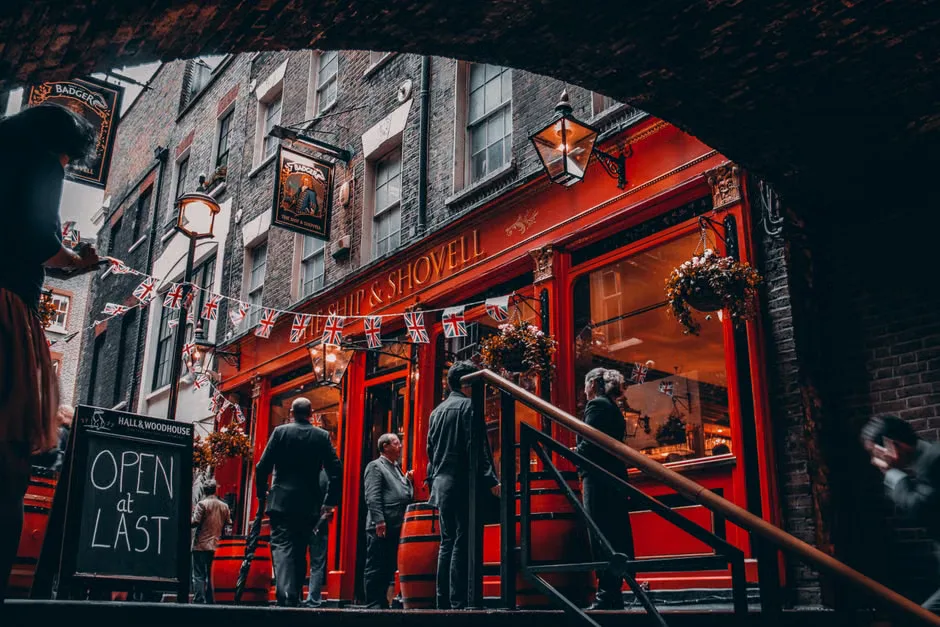 Football fans watch an England match on television inside a crowded pub.