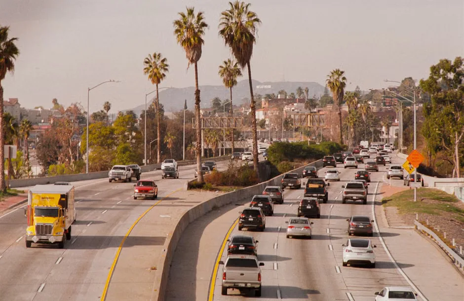 Traffic moves along a Los Angeles freeway at dusk.