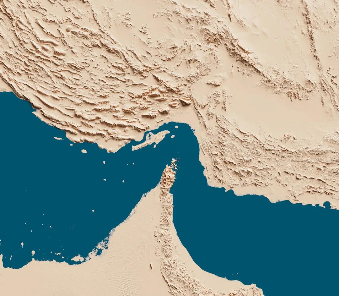 Cargo ships and port infrastructure in the UAE with the Strait of Hormuz highlighted on a regional map.