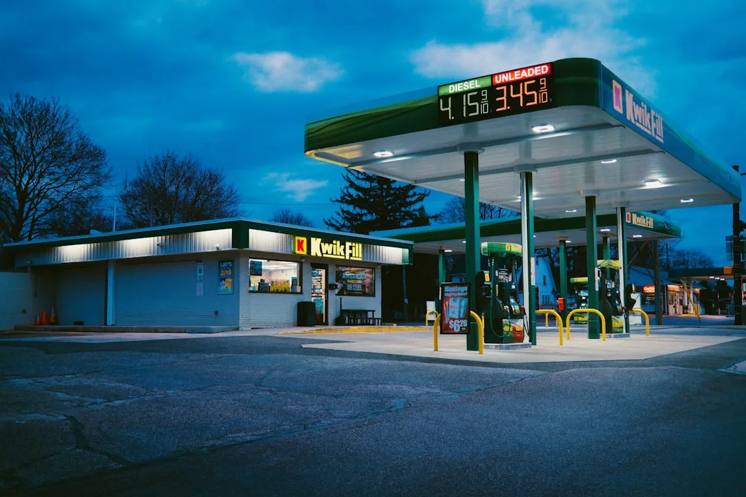 Gas prices displayed at a US gas station with a financial chart symbolizing easing inflation.